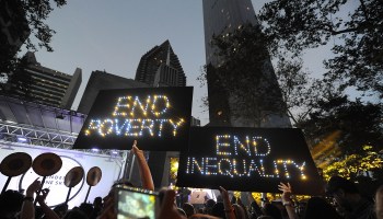 Signs reading "End Poverty" and "End Inequality" are held up during a 2015 demonstration in New York City.