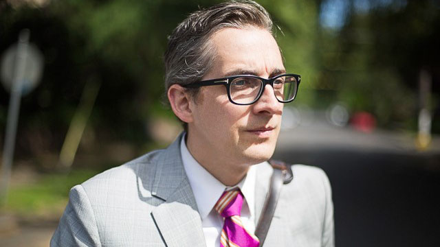 A portrait of advertising creative producer Mike Merrill in a suit.
