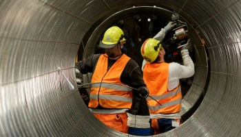 Two workers construct the wall of the Nord Stream 2 pipeline.