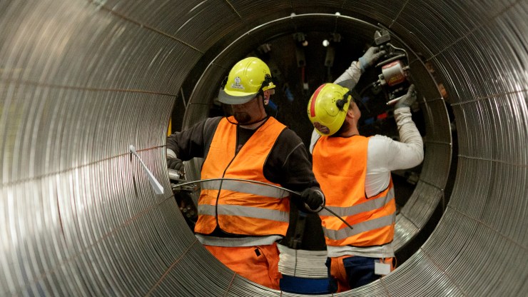 Two workers construct the wall of the Nord Stream 2 pipeline.