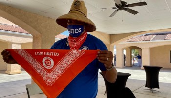 Rico Peralta holds up a bandana with messages in multiple languages spoken in the Central Valley.