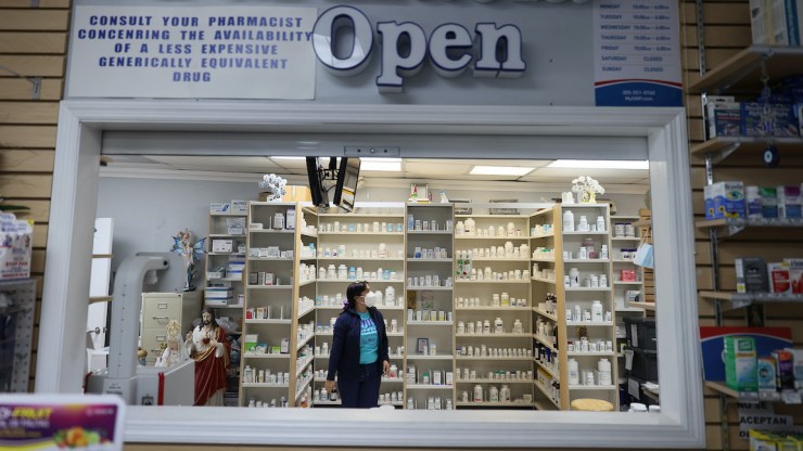 A pharmacist looks for medicine in a local pharmacy.