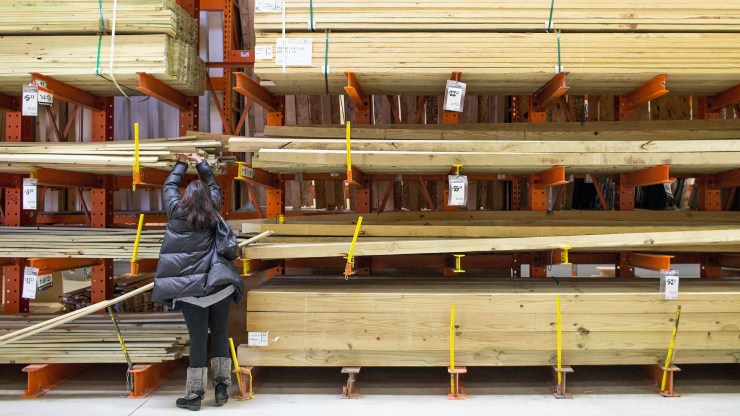 A person reaches for lumber at a sales outlet.