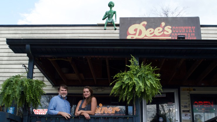 Daniel Walker (left) and Amy Dee Richardson stand on the porch outside Dee’s Country Cocktail Lounge, a self-described '70s inspired "dive."