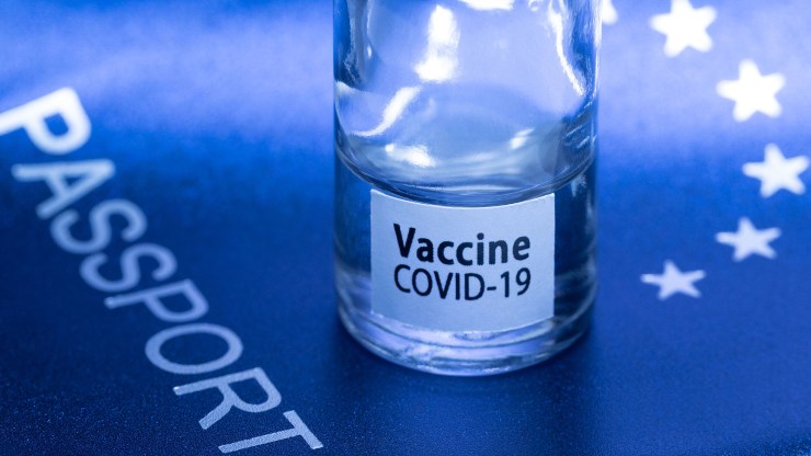 A picture taken on March 3, 2021 in Paris shows a vaccine vial reading "COVID-19 vaccine" on top of a European passport.