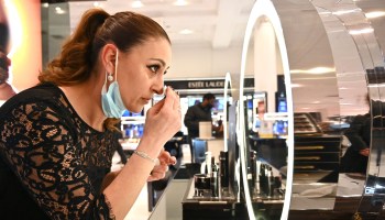 A customer tries on makeup in a department store.