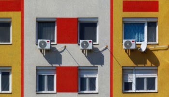 Air-conditioning window units along the side of a building.