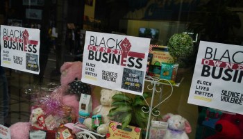 A "Black Owned Business" sign hangs in a window