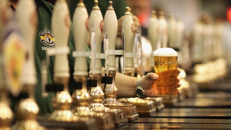 A pint of beer is served through a row of taps.