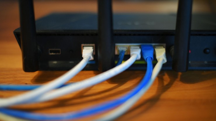 Ethernet cables are seen running from the back of a wireless router in Washington, D.C., on March 21, 2019.