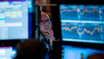 A man seems concerned while looking at computer screens. The lofty levels of stock prices are among the risks to financial stability the Fed is monitoring.