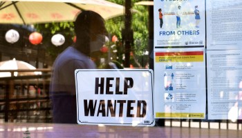 VA "Help Wanted" sign is posted beside coronavirus safety guidelines at a restaurant in Los Angeles, California, on May 28, 2021.