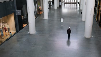 A person walks through an empty shopping mall.