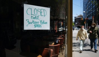 A sign reading "Closed until further notice sorry" hangs in a restaurant window.
