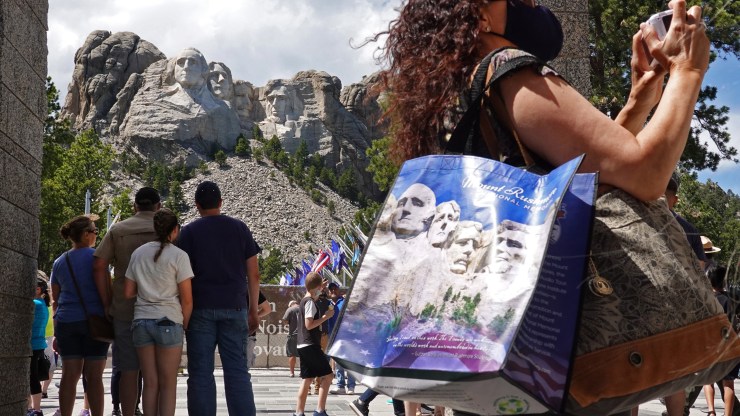 Above, tourists visit Mount Rushmore National Monument last year.