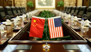 The Chinese and U.S. flags are propped up on a conference table.