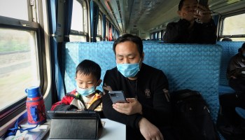 A father with his son on a low-cost train heading into the Chinese countryside. People in rural China cite the cost of raising a child as a main reason they don't want to have more children.