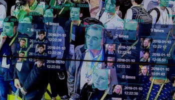 A demonstration of facial recognition software shows a crowd of people with each of their faces targeted by a blue box.