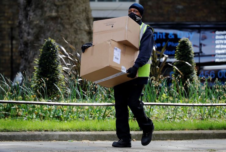 A Hermes delivery courier carries boxes as he makes a delivery to 10 Downing Street, the official residence of Britain's Prime Minister, in central London on May 5, 2020.