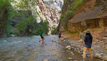 Hikers take pictures at the entrance of the famous Narrows hike, currently closed, along the North Fork of the Virgin River in Zion National Park on May 15, 2020 in Springdale, Utah.