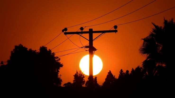 The sun sets behind power lines in Los Angeles, California, on September 3, 2020.
