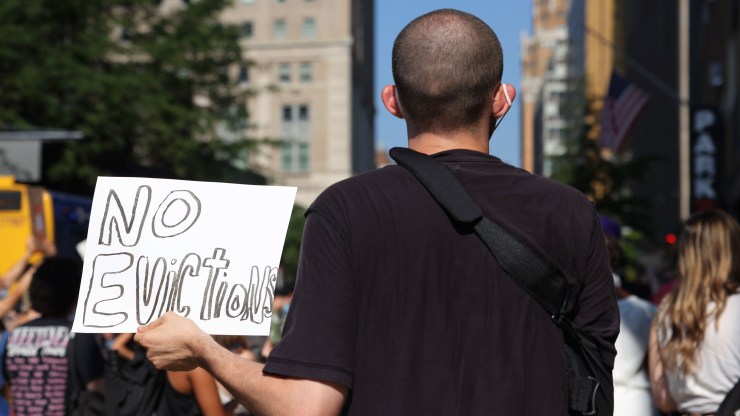 A demonstrator holds up a sign that says "No Evictions" as he listens to speakers during a "Resist Evictions" rally to protest evictions on August 10, 2020 in New York City.