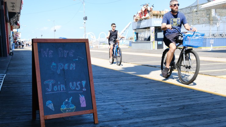 People ride bikes along a boardwalk in the coastal community of Wildwood, New Jersey, in the days leading up to Memorial Day.