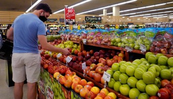 A man views produce at a grocery store.