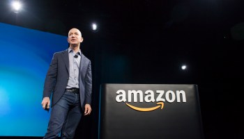 Amazon CEO Jeff Bezos stands on stage next to Amazon branding and presents the company's first smartphone, the Fire Phone, on June 18, 2014 in Seattle, Washington.