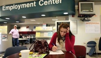 A woman fills out forms at an employment center.