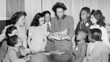 Sadie T. M. Alexander, the first African American to receive a Ph.D. in economics in the United States, reads a comic book to children in 1948.