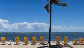 Empty lounge chairs are seen on a deserted Florida beach.