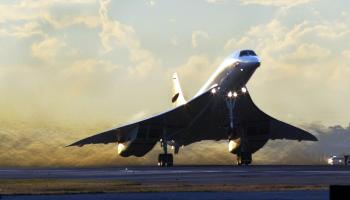 A Supersonic Concorde plane takes flight off a runway.