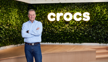 A photo of Andrew Rees in front of a Crocs sign.