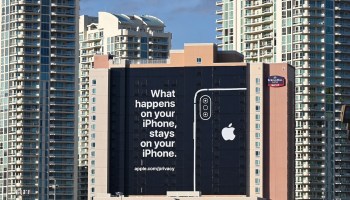 A 2018 black and white billboard in Las Vegas reads "What happens on your iPhone, stays on your iPhone." It includes a drawing of the iPhone and provides the link to Apple's privacy policy.