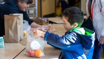 A 5-year-old picks up a free school lunch at Olympic Hills Elementary School on March 18, 2020, in Seattle, Washington.