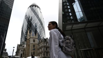 A pedestrian passes the skyscraper informally known as the Gherkin in London's financial district, which seeks to extend its international ties.