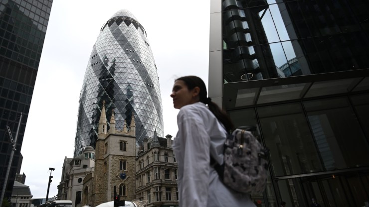 A pedestrian passes the skyscraper informally known as the Gherkin in London's financial district, which seeks to extend its international ties.