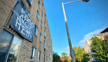 A banner on an apartment buildings says "FOOD NOT RENT."