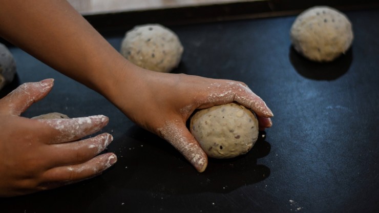 A baker works with balls of dough.