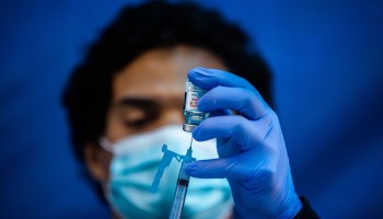 Medical worker Robert Gilbertson loads a syringe with the Moderna COVID-19 vaccine at Kedren Community Health Center, in South Los Angeles in February.