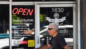 A man walks past a restaurant with an illuminated "Open" sign on May 5, 2021 in Los Angeles, California.