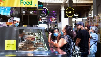 Face masks continue to be worn as people wait for their food at Grand Central Market in Los Angeles on June 14, 2021.