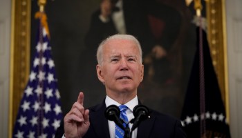 President Joe Biden speaks at a microphone.