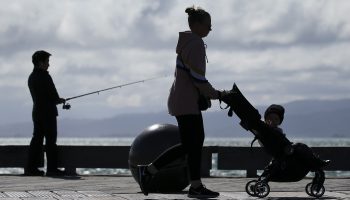 A woman pushes a child in a stroller.