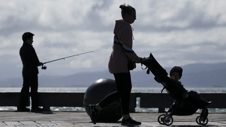 A woman pushes a child in a stroller.