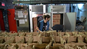 A volunteer prepares donated groceries for food-insecure families. Claire Babineaux-Fontenot, CEO of Feeding America, says there may be a "spike in need" for food assistance later this year.