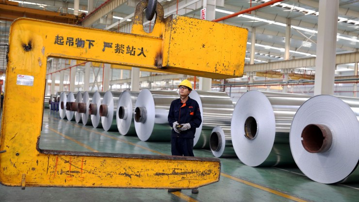 This photo taken on May 20, 2017 shows a Chinese worker loading aluminum tapes at an aluminum production plant in Huaibei, east China's Anhui province.