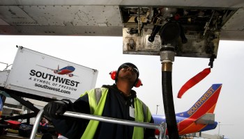A worker monitors a fueling hose as he pumps fuel into a plane in May 2008 at Oakland International Airport in Oakland, California.
