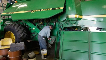 A John Deere employee uses a wrench while working on a large agricultural combine in Hampshire, Illinois.